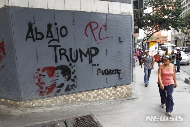 【카라카스=AP/뉴시스】6일(현지시간) 베네수엘라 수도 카라카스에서 행인들이 반 트럼프 낙서가 그려진 벽 앞을 지나고 있다. 2019.08.07
