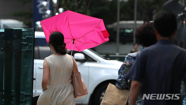 【서울=뉴시스】추상철 기자 =지난 11일 서울 종로구 세종대로 사거리 인근에서 강풍에 시민이 쓰고 있던 우산이 뒤집혔다. 2019.08.11. scchoo@newsis.com