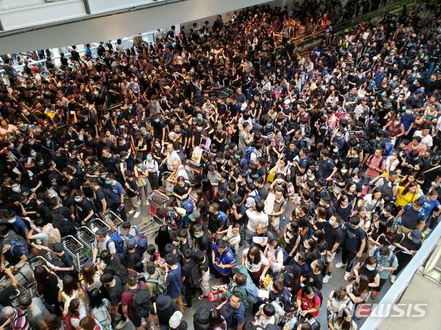 홍콩 국제공항 오후 6시(한국시간) 모습  시위대가 몰려오자 당황한 여객들이 공항을 빠져나가기 바쁘다 <CNN 캡쳐>