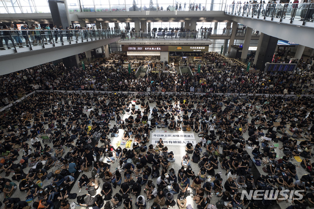 【홍콩=AP/뉴시스】12일(현지시간) 홍콩 국제공항 입국장에 5천여 명의 홍콩 민주화 시위대가 앉아 연좌시위를 벌이고 있다. 홍콩 국제공항은 성명을 통해 이번 시위가 공항 운영을 “심각하게 방해했다”고 밝히며 이후 홍콩발 항공편에 대한 모든 탑승 수속 서비스를 중단했다. 2019.08.12.