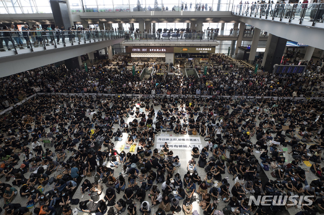 【홍콩=AP/뉴시스】12일(현지시간) 홍콩 국제공항 입국장에 5천여 명의 홍콩 민주화 시위대가 앉아 연좌시위를 벌이고 있다.  홍콩 국제공항은 성명을 통해 이번 시위가 공항 운영을 “심각하게 방해했다”고 밝히며 이후 홍콩발 항공편에 대한 모든 탑승 수속 서비스를 중단했다. 2019.08.12. 