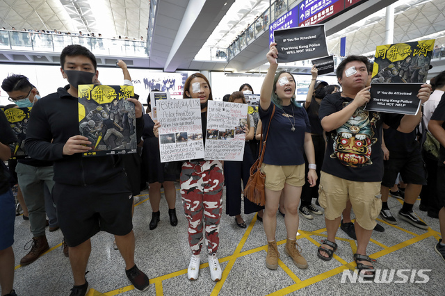 【홍콩=AP/뉴시스】12일(현지시간) 홍콩 국제공항 입국장에서 오른쪽 눈에 안대를 붙인 시위대가 경찰의 고무탄 발사로 한 여성이 실명한 것에 대해 항의하는 시위를 벌이고 있다.  지난 11일 홍콩 경찰이 고글을 착용한 한 여성 시위자에게 고무탄을 쏴 고글을 깨고 들어간 탄환이 여성을 실명시킨 것으로 전해진 바 있다. 2019.08.12. 