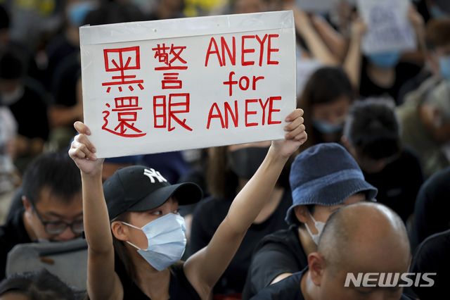 【홍콩=AP/뉴시스】12일(현지시간) 홍콩 국제공항 입국장에서 한 시위 여성이 "흑경(나쁜 경찰), 내 눈 살려내"라고 쓰인 손팻말을 들고 연좌 시위를 벌이고 있다.  지난 11일 홍콩 경찰이 고글을 착용한 한 여성 시위자에게 고무탄을 쏴 고글을 깨고 들어간 탄환이 여성을 실명시킨 것으로 전해진 바 있다. 2019.08.13.