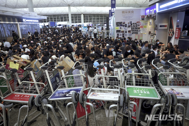 【홍콩=AP/뉴시스】 13일 오후 홍콩의 '범죄인 인도 법안(송환법)' 반대 시위대가 공항 내 카트를 쌓아 차벽을 이루며 대규모의 농성을 벌이고 있다. 지난 이틀 동안 탑승 수속이 중단됐던 홍콩국제공항은 14일(현지시간) 오전 업무를 재개한 상황이다. 2019.8.14.