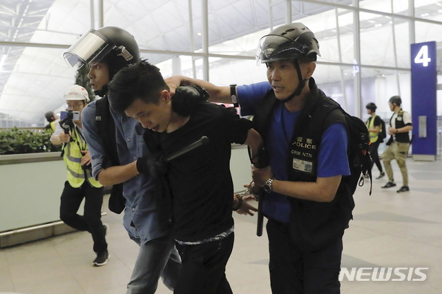 【홍콩=AP/뉴시스】13일 밤 홍콩 국제공항에서 진압경찰이 '범죄인 인도법'에 반대하는 시위자를 연행하고 있다. 홍콩 국제공항은 시위대의 점거가 이어지면서 13일에도 극심한 혼란을 빚었다. 2019.08.14