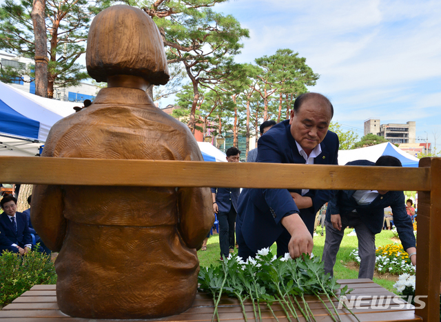 【광주=뉴시스】변재훈 기자 = 14일 오전 광주 서구 평화의 소녀상 앞에서 일본군 위안부 피해자 기림의 날 기념행사가 열리고 있다. 참석자들이 추모의 뜻을 담아 소녀상에 헌화하고 있다. 2019.08.14.   wisdom21@newsis.com