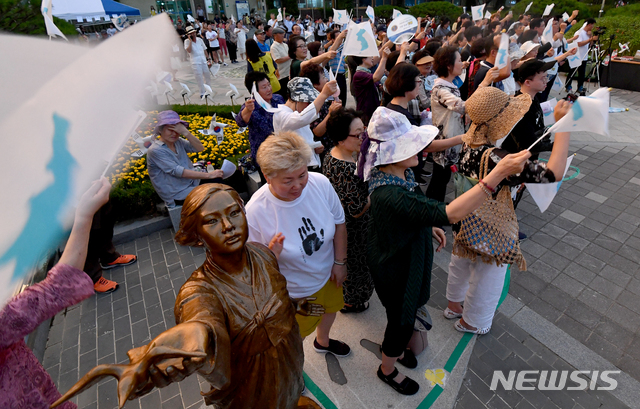 【광주=뉴시스】신대희 기자 = 세계 일본군 위안부 기림의 날인 14일 오후 광주 북구청 평화의 소녀상 광장에서 북구 평화인간띠잇기 추진위원회 주관으로 인간 띠잇기 행사가 열리고 있다. 북구 주민들은 일제강점기 위안부·강제징용 피해자들에게 용서를 구하지 않고 역사를 왜곡하는 일본 아베 정권을 강하게 규탄했다. 2019.08.14. sdhdream@newsis.com