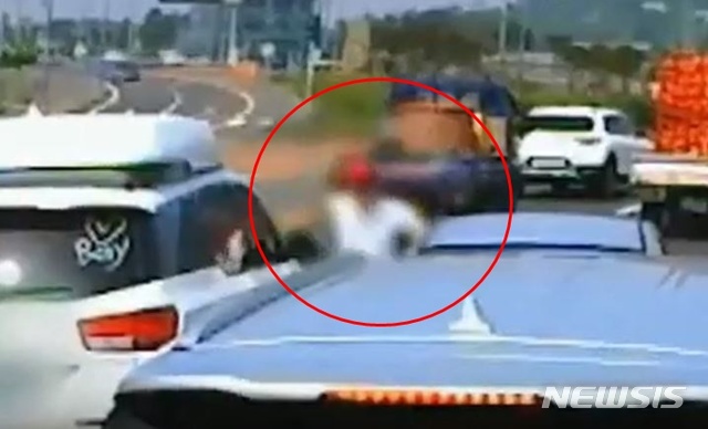 [제주=뉴시스]지난해 7월4일 제주시 조천읍한 도로 위에서 카니발 차량 운전자 A(33)씨가 주먹을 휘두르고 있다. (사진=유튜브 영상 캡처)