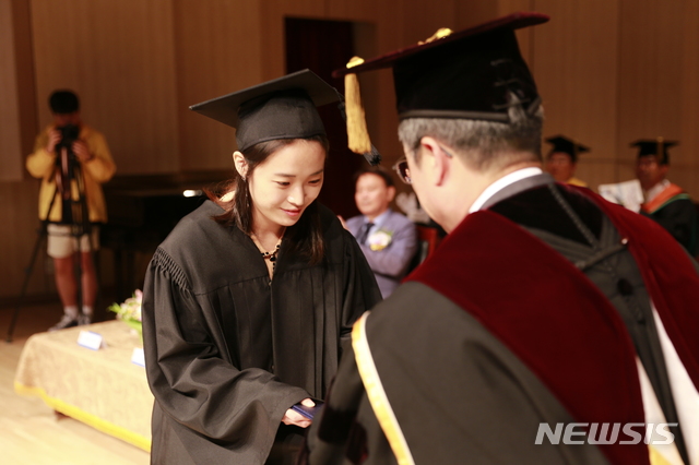 20일 곽병선 군산대학교 총장(오른쪽)이 인문대학 이혜빈 학생에게 학위증을 수여하고 있다. (사진=군산대 제공)