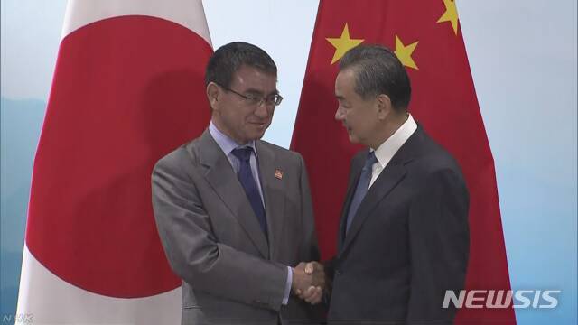20일 악수하는 왕이 중국 외교부장과 고노 다로 일본 외무상 <NHK 캡쳐>
