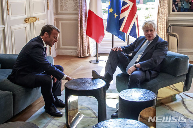 【파리=AP/뉴시스】 22일(현지시간) 프랑스 대통령궁인 엘리제궁을 방문한 보리스 존슨(오른쪽) 영국 총리가 에마뉘엘 마크롱 프랑스 대통령과의 정상회담 중 테이블에 발을 올린 사진이 공개되며 양국 누리꾼들 사이에서 소란이 일고 있다. 2019.8.23.