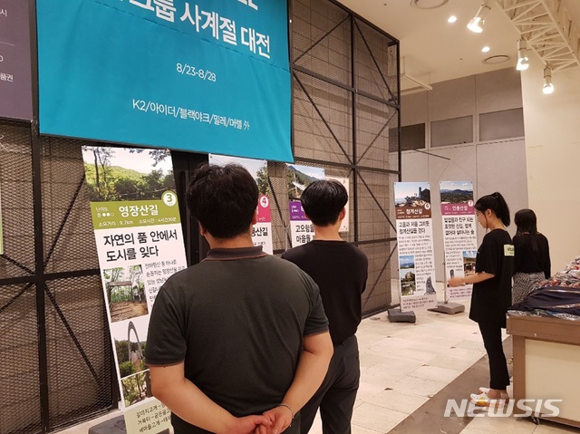  성남누비길 7개 구간별 사진과 설명이 담긴 대형 배너 전시장을 찾은 시민들.