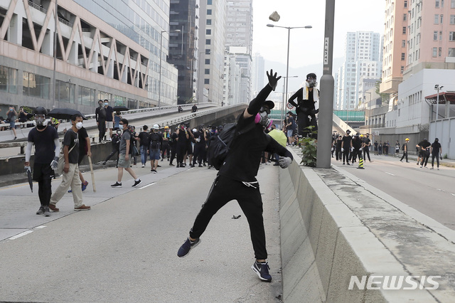 【홍콩=AP/뉴시스】24일(현지시간) 홍콩 거리에서 한 시위 대원이 시위 중 경찰을 향해 돌을 던지고 있다. 시위대는 쿤통 등지에서 바리케이드를 치고 경찰과 대치했고, 경찰은 시위대를 향해 최루탄을 쏘며 진압을 시도했다.홍콩 중고생들은 정부가 시위대의 요구 조건을 수용하지 않을 경우 2주 동안 수업을 거부한다고 밝혔다. 2019.08.24.