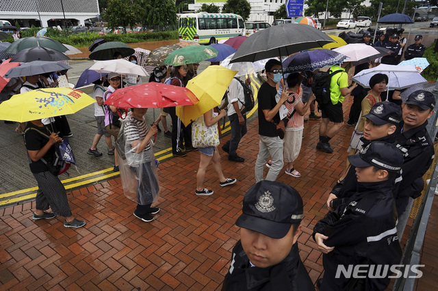 【홍콩=AP/뉴시스】우산을 쓴 홍콩 시위대가 25일 경찰 앞으로 지나가고 있다. 2019.08.25 