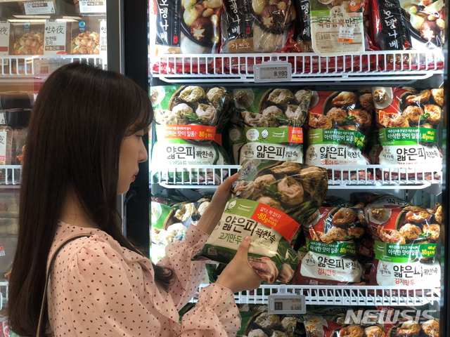 【서울=뉴시스】한 소비자가 서울의 한 대형마트에 진열된 풀무원식품 '얇은피꽉찬속 만두'를 고르고 있다.
