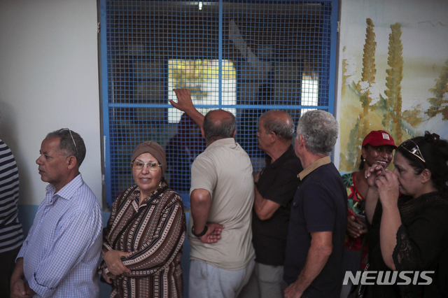 대통령선거 1차전이 치러지는 15일 튀니지 수도 튀니스에서 주민들이 투표소 앞에 줄을 서 기다리고 있다. 1200만 인구 중 700만 명이 자발적으로 유권자 등록을 마쳤다  AP