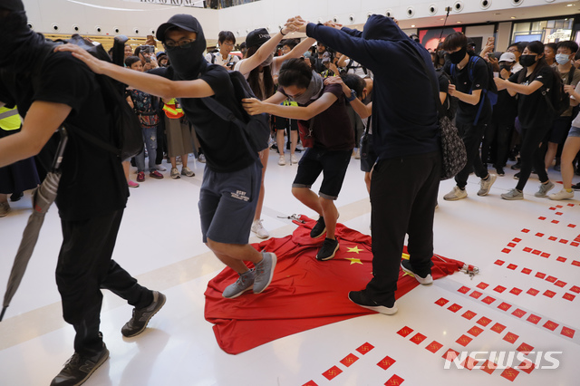 【홍콩=AP/뉴시스】22일 홍콩 샤틴역 인근 쇼핑몰에서 범죄인 인도법(송환법) 반대 시위대가 중국 국기 오성홍기를 밟는 퍼포먼스를 펼치고 있다. 2019.09.23 