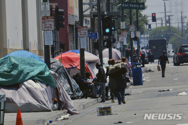 【 로스앤젤레스= AP/뉴시스】 LA시내 주요거리마다 인도의 노숙자 천막들이 즐비해지면서 시 당국과 주민들이 골치를 앓고 있다. 시의회에서는 시내 중심가의 노숙을 금지하자는 제안이 나왔다가 그러면 노숙자들이 모두 범죄인이 될 수 있다는 반발과 시위에 부닥쳐 좌절당했다.