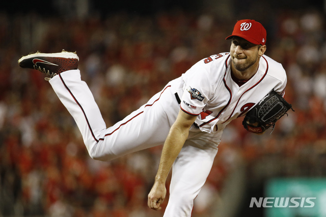 Washington Nationals starting pitcher Max Scherzer follows through on a pitch to the Milwaukee Brewers in the first inning of a National League wild card baseball game, Tuesday, Oct. 1, 2019, in Washington. (AP Photo/Patrick Semansky)
