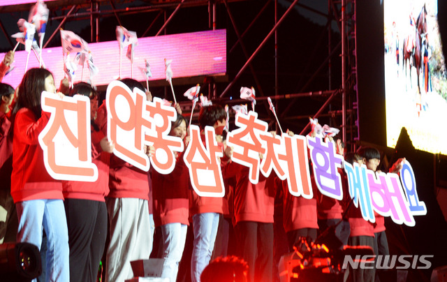 【진안=뉴시스】 김얼 기자= '백세인생, 천년기운, 진안홍삼'이라는 주제로 2019 진안홍삼축제가 개막한 9일 전북 진안군 마이산 북부에 마련된 특설무대에서 축하공연에 나선 공연팀이 '진안홍삼축제 함께해요'라고 적힌 손피켓을 들고 공연의 열기를 더하고 있다. 2019.10.09. pmkeul@newsis.com