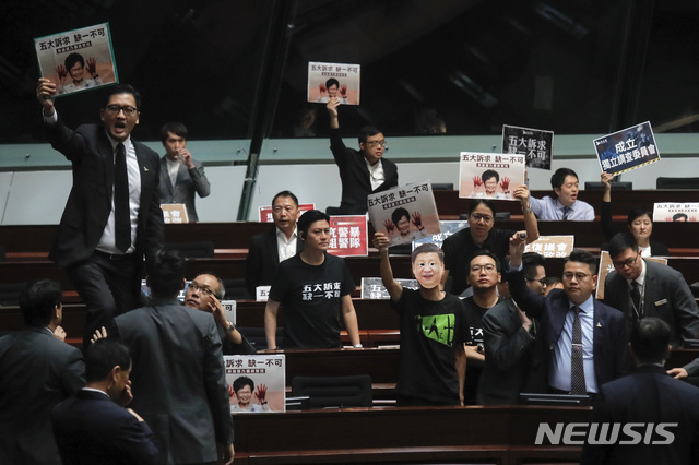 【홍콩=AP/뉴시스】16일 홍콩 입법회의 회의실에서 캐리 람 홍콩 행정장관이 시정연설을 하기 위해 연단에 오르자 야당 의원들이 반발했다. 야당 의원들은 람 행정장관에게 시위대가 주장하는 5가지 요구안을 수용할 것을 주장했다. 2019.10.16.