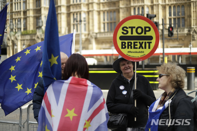 【런던=AP/뉴시스】 15일(현지시간) 영국의 유럽연합(EU) 탈퇴를 반대하는 시위대들이 런던 국회의사당 앞에서 손팻말과 유럽연합기를 들고 서있다. 2019.10.17. 