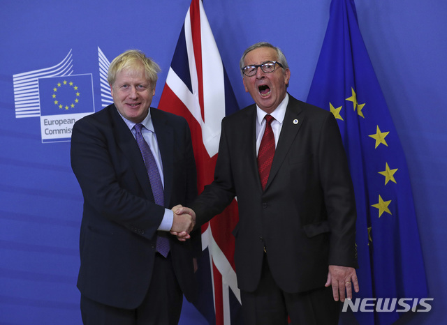 【브뤼셀=AP/뉴시스】보리스 존슨 영국 총리(왼쪽)와 장 클로드 융커 유럽연합(EU)집행위원장이 17일(현지시간) 벨기에 브뤼셀 EU 본부에서 만나 악수하고 있다. 이날 양측은 브렉시트안에 합의했다고 밝혔다. 2019.10.17 