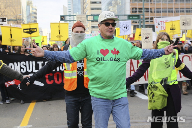 【에드먼턴=AP/뉴시스】18일(현지시간) 캐나다 앨버타주 에드먼턴의 앨버타 의회 앞에서 스웨덴 환경운동가 그레타 툰베리와 기후행동 참가자들이 집회와 행진을 위해 모인 가운데 석유 및 가스산업 지지자가 앞에 서서 반대 시위를 벌이고 있다. 2019.10.19.