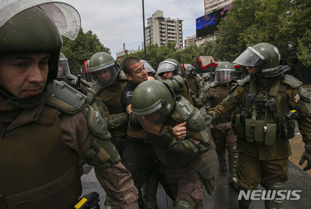 【산티아고(칠레)=AP/뉴시스】비상사태가 선포된 칠레 수도 산티아고에서 19일 군인들이 한 시위자를 체포하고 있다. 18일 지하철 요금 인상에 반대하는 학생들의 항의 시위가 폭동으로 변하며 지하철 운행이 마비되자 칠레는 산티아고에 비상사태를 선포했고 군사독재 이후 29년만에 군인들이 치안 유지를 위해 시내 순찰에 나섰다. 2019.10.20