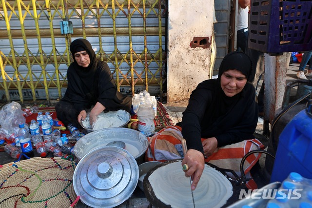 【바그다드(이라크)=AP/뉴시스】자원봉사 이라크 여성들이 30일 바그다드에서 시위대원들에 제공할 빵을 굽고 있다. 최루가스와 실탄 사격까지 동원한 진압 경찰의 노력에도 불구하고 이라크의 반정부 시위는 30일 더욱 세력이 커지고 있다. 2019.10.31