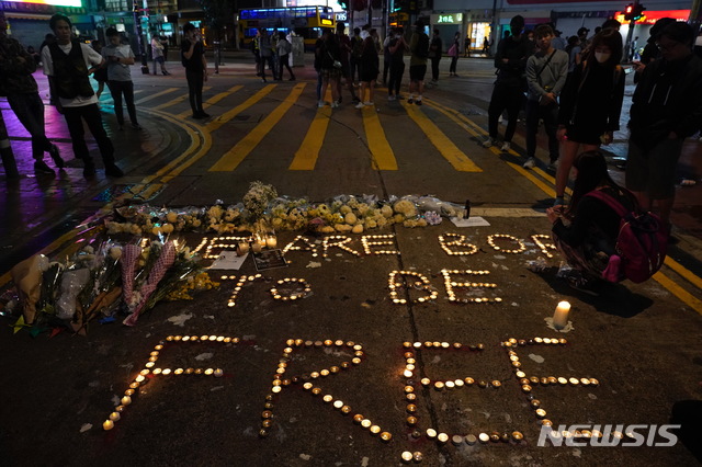 【홍콩=AP/뉴시스】8일 홍콩 도심에서 경찰 시위 진압 첫 사망자인 대학생 차우츠록(周梓樂) 추모 집회에서 참가자들이 양초를 이용해 '우리는 자유를 위해 태어났다(We are Born to be Free)'라는 글씨를 세기고 있다. 2019.11.09 