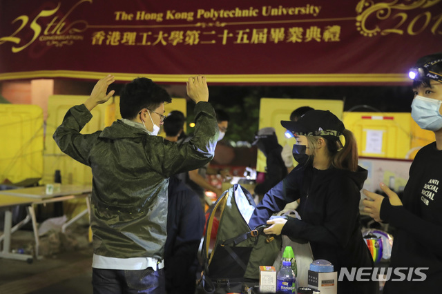 【홍콩=AP/뉴시스】15일 홍콩 폴리테크닉 대학에서 시위대가 한 남자의 가방을 검색하고 있다. 홍콩에서는 이날 오후까지 평화적인 분위기를 느낄 수 있었으나 밤이 되면서 시위대와 경찰이 다시 충돌했다. 2019.11.16 