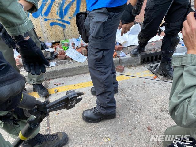 【홍콩=AP/뉴시스】17일(현지시간) 홍콩 폴리텍대학 시위 현장에서 공보관 조끼를 입은 한 경찰관이 시위대가 쏜 화살에 맞아 종아리에 화살이 꽂혀 있다. 이 경찰관은 현장에서 응급처치 후 병원으로 옮겨졌다. 2019.11.17. 