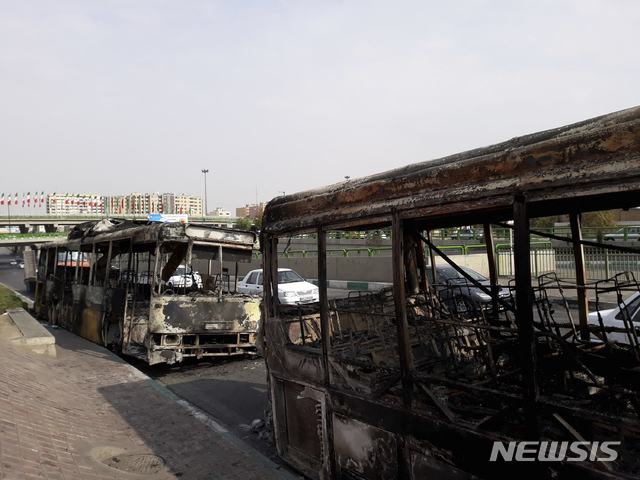 【테헤란=AP/뉴시스】이란 수도 테헤란에서 정부의 휘발유 가격 50% 인상에 항의하는 시민들의 시위가 벌어져 지난달 17일(현지시간) 도로에 불에 탄 버스들이 놓여 있다. 2019.12.16