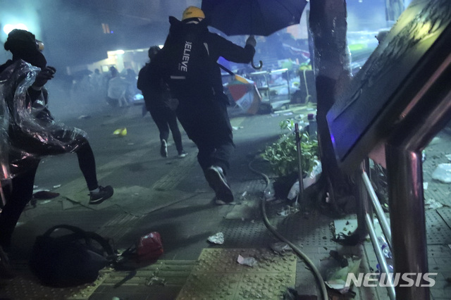[홍콩=AP/뉴시스] 홍콩 이공대 내에서 18일 새벽 시위 학생들이 학교 안으로 들어온 경찰을 피해 밖으로 도망치고 있다. 2019.11.18