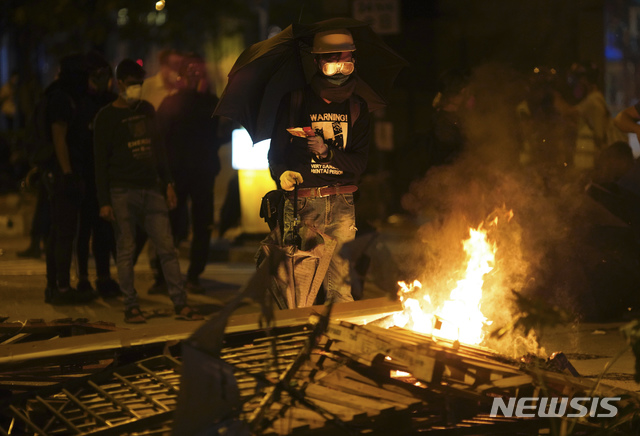 [홍콩=AP/뉴시스]홍콩 곳곳에서 18일 밤과 19일 새벽까지 격렬한 시위가 이어진 가운데 일단의 시위대가 방어선을 만들기 위해 불을 지르고 있다. 2019.11.19 