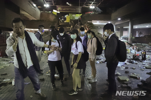 [ 홍콩=AP/뉴시스]홍콩이공대에서 19일 학교 관계자가 18세 이하 시위참가 학생들을 캠퍼스 밖으로 내보내기 위해 누군가와 전화통화를 하고 있다. 이날 경찰은 고등학교 교장들의 요청에 따라 이공대 내에 있는 일부 미성년자들의 귀가를 허용했다. 2019.11.19 