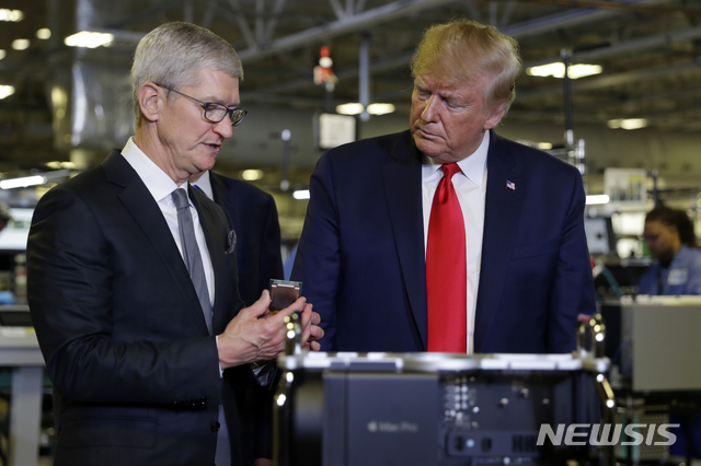 [오스틴=AP/뉴시스]도널드 트럼프 미국 대통령이 20일(현지시간) 미 텍사스주 오스틴의 애플 공장을 방문해 팀 쿡 애플 최고경영자(CEO)와 함께 생산 라인을 둘러보고 있다. 2019.11.21.