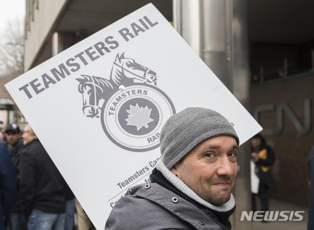 [몬트리올= AP/뉴시스] 지난 해 11월 캐나다 국영철도회사 파업에 참가한 철도노조원이 소속 지부의 손팻말을 들고 몬트리올의 철도회사 본사 앞에서있다.  