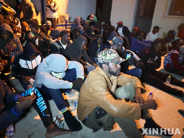 [ 트리폴리= 신화/뉴시스] 지난해 11월 30일 리비아 해안경비대가 지중해에서 구조한 불법 이민들이 트리폴리의 대기소에서 모여 있다. 리비아 해경은 올 1월 26일에도 지중해에서 각각 49명과 29명의 유럽행 불법이민들을 구조해 트리폴리에 상륙시켰다. 