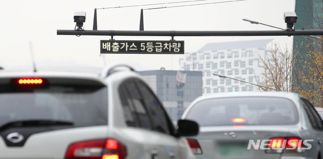 [서울=뉴시스]김선웅 기자 = 서울 사대문안 '녹색교통지역(한양도성 내 16.7㎢)' 배출가스 5등급 차량 운행제한이 시작된 1일 서울 중구의 한 도로에 단속 카메라가 설치돼있다.  녹색교통지역은 종로구 8개동과 중구 7개동이 포함되며 이날부터 저공해 조치를 하지 않은 전국의 모든 5등급 차량이 녹색교통지역에 진입하면 과태료 25만원(1일 1회)이 부과된다. 단속 시간은 매일 오전 6시부터 오후 9시까지다. 2019.12.01. mangusta@newsis.com