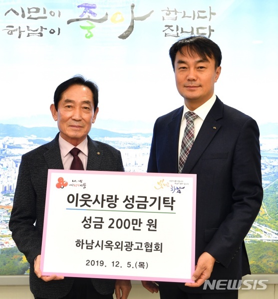 하남시옥외광고협회 유진천 회장(왼쪽)은 김상호 시장에게 이웃돕기 성금 200만원을 기탁했다.