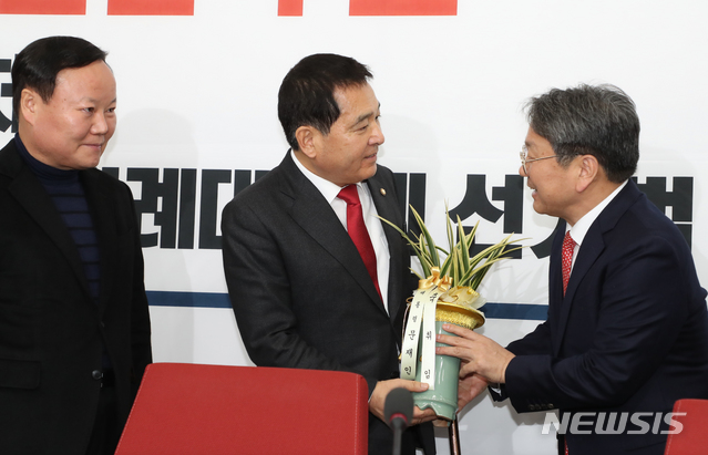 [서울=뉴시스]김명원 기자 = 강기정 청와대 정무수석이 9일 오후 서울 여의도 국회 자유한국당 원내대표실을 찾아 심재철 신임 원내대표에게 문재인 대통령 축하난을 전달하고 있다. 2019.12.09. kmx1105@newsis.com