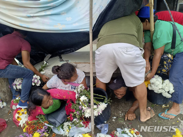 [다바오=AP/뉴시스] 15일 필리핀 민다나오섬 다바오주에서 지진이 발생했다. 지진으로 벽이 무너져 꽃을 팔던 노점상을 덮쳤다. 2019.12.15. 