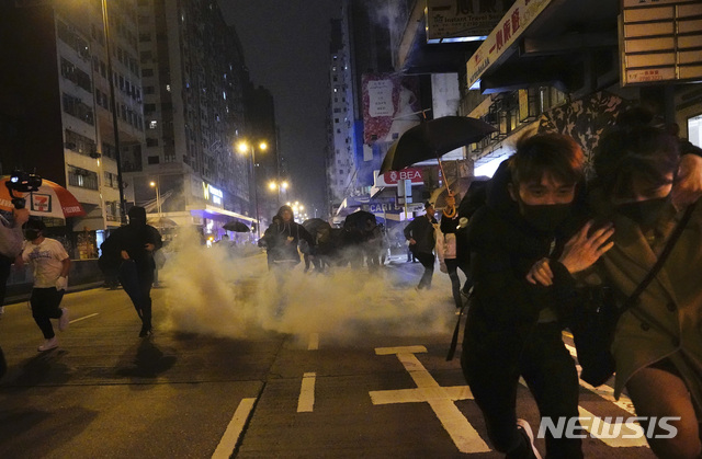 [홍콩=AP/뉴시스]새해 첫날인 1일 새벽 홍콩 시내에서 시위 참가자들이 경찰이 쏜 최루탄을 피해 달아나고 있다. 2020.01.01 