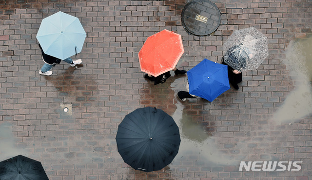 [대구=뉴시스] 이무열 기자 = 6일 오후 대구 중구 동성로 야외광장에서 우산을 쓴 시민들이 발걸음을 재촉하고 있다. 2020.01.06.lmy@newsis.com