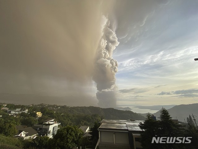 [타가이타이=AP/뉴시스] 12일 필리핀 수도 남쪽 호수의 한 섬에 소재한 탈 화산에서 연기와 재가 분출해 하늘로 치솟고 있다. 2020. 1. 12. 