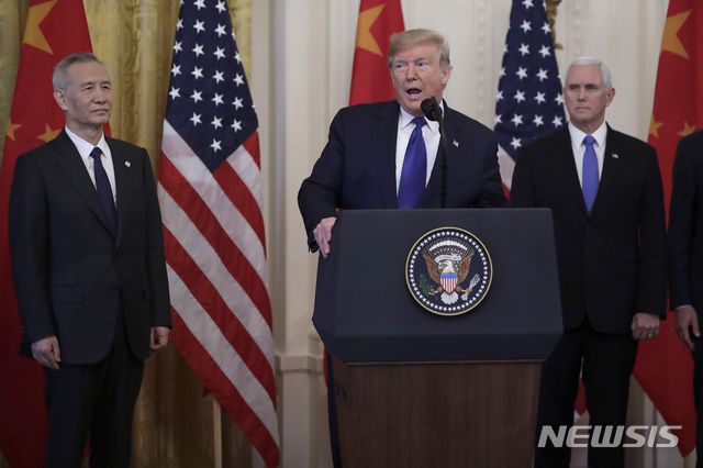 [워싱턴=AP/뉴시스]도널드 트럼프 미국 대통령(가운데)이 15일(현지시간) 백악관에서 류허 중국 국무원 부총리(왼쪽), 마이크 펜스 부통령(오른쪽)과 함께 미중 1단계 무역합의 서명식에 참석해 발언하고 있다. 2020.01.16.