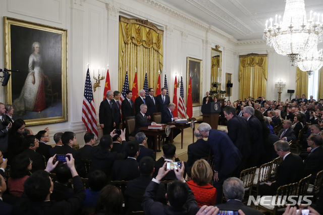 [워싱턴=AP/뉴시스]15일(현지시간) 미국 워싱턴 백악관에서 류허 중국 부총리(왼쪽)과 도널드 트럼프 미국 대통령(오른쪽)이 앉아 1단계 미중 무역합의문에 서명하고 있다. 2020.01.16.