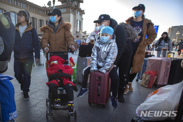 [베이징=AP/뉴시스]20일(현지시간) 중국 베이징의 베이징 철도역 앞에 여행객들이 마스크를 쓰고 이동하고 있다. 2020.01.20. 